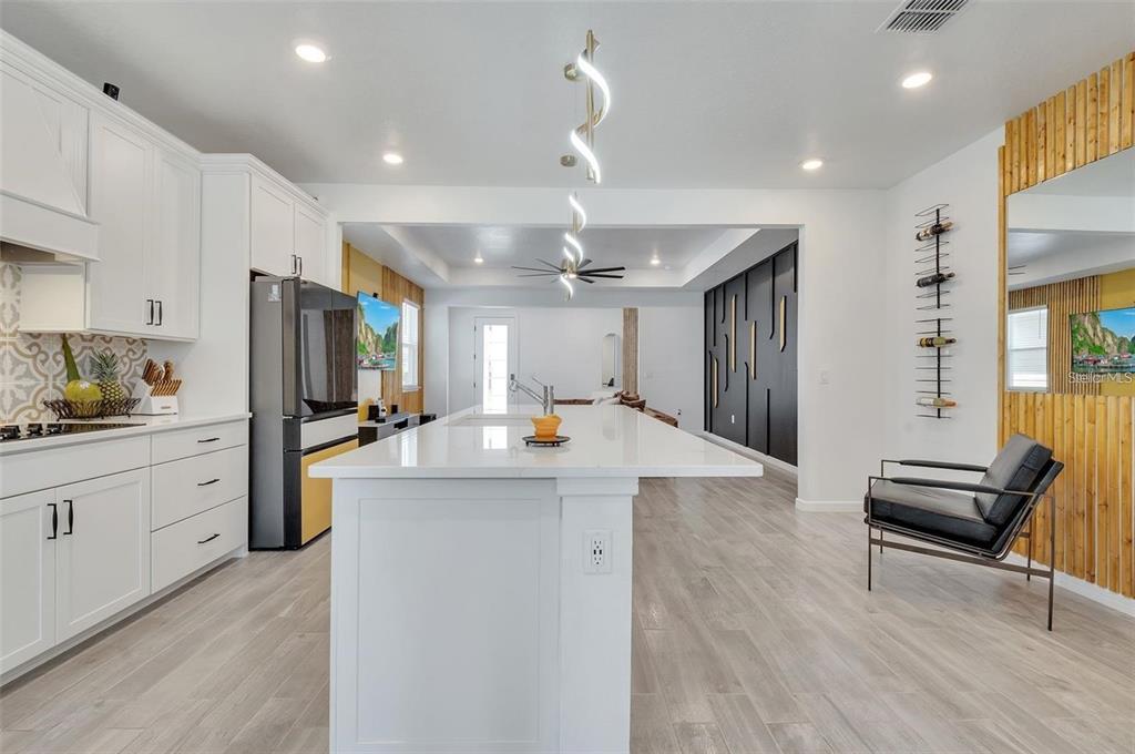 6494 Rover Way St. Cloud, FL 34771 - Photo 15 of 50 a kitchen with stainless steel appliances kitchen island granite countertop a refrigerator a stove and a sink with wooden floor