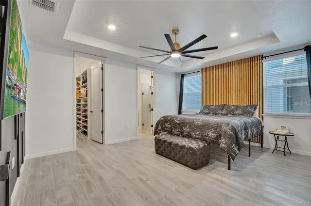 a spacious bedroom with a large bed and a chandelier