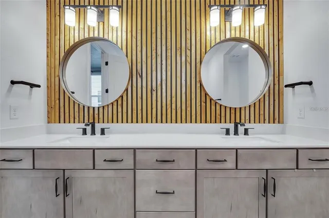 a bathroom with a sink a mirror and a next to a window