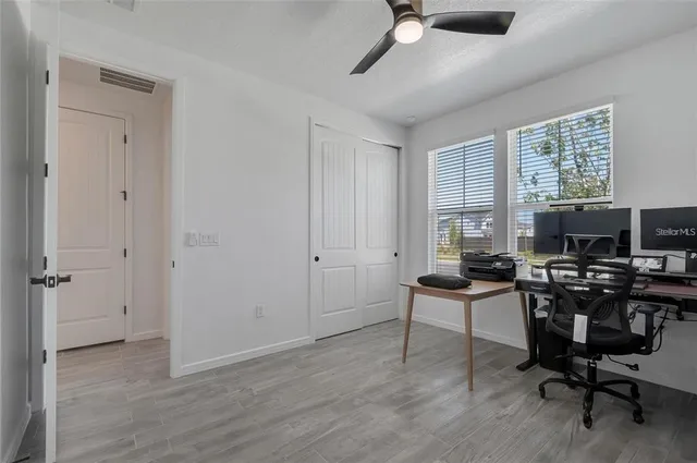 a view of a workspace with furniture and a window