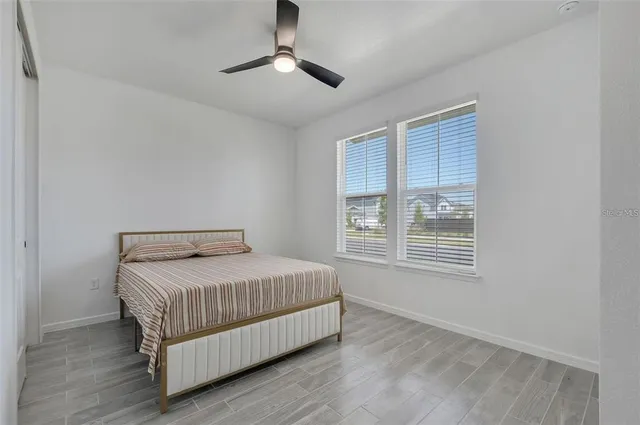 a bedroom with a bed chandelier and window