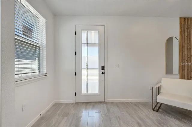 an empty room with a window and wooden floor