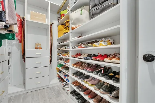 a view of walk in closet with clothes and shoes