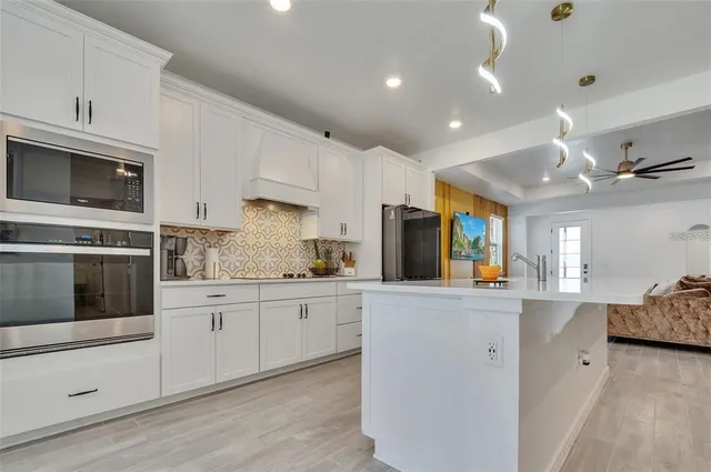 a kitchen with stainless steel appliances kitchen island granite countertop a stove sink and microwave
