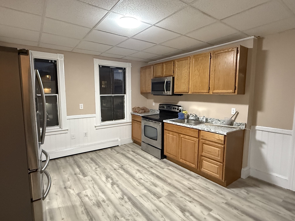 9 Winslow Street, Unit 2 Worcester, MA 01609 - Photo 2 of 10 a kitchen with stainless steel appliances granite countertop a stove a sink and a refrigerator