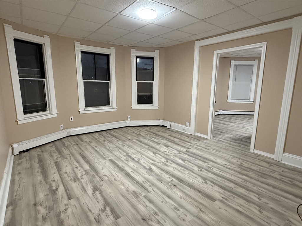 9 Winslow Street, Unit 2 Worcester, MA 01609 - Photo 4 of 10 a view of an empty room with wooden floor and windows