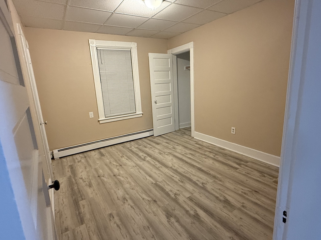 9 Winslow Street, Unit 2 Worcester, MA 01609 - Photo 6 of 10 a view of an empty room with wooden floor and a window