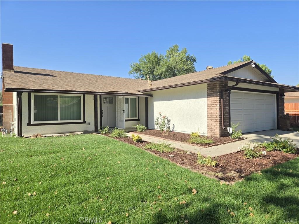 a front view of a house with a garden and yard