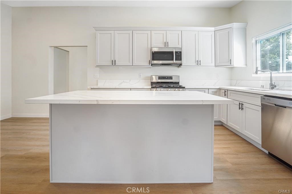 1594 Morgan Road San Bernardino, CA 92407 - Photo 15 of 31 a kitchen with kitchen island a sink a stove a microwave and wooden cabinets