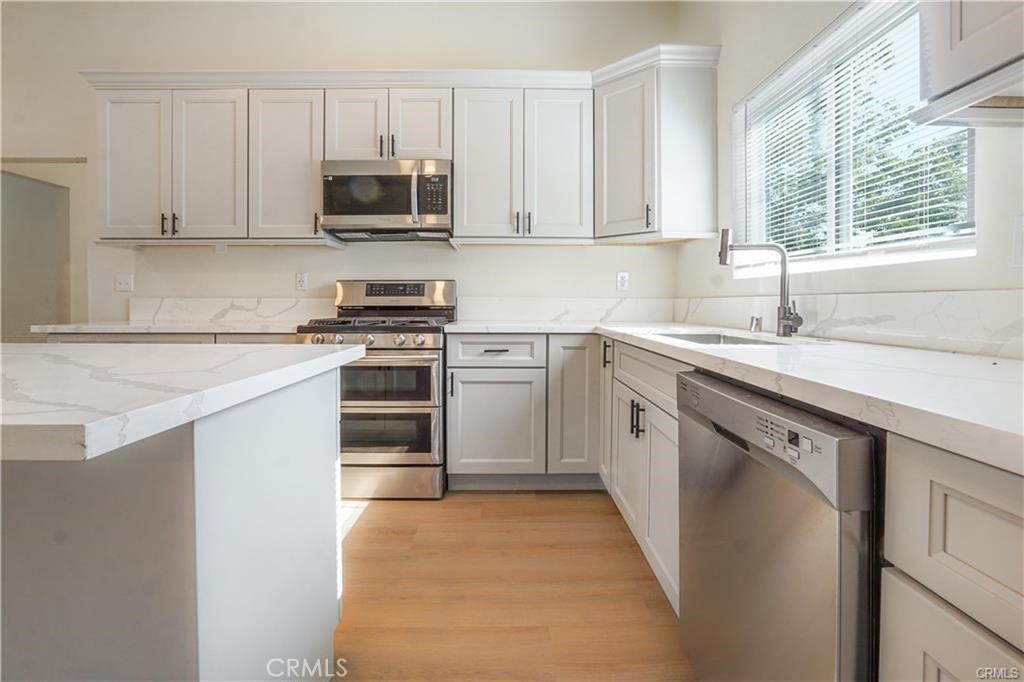 1594 Morgan Road San Bernardino, CA 92407 - Photo 16 of 31 a kitchen with stainless steel appliances granite countertop a stove a sink and a microwave