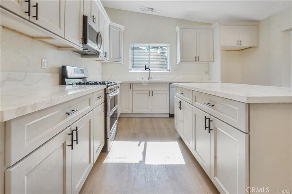 1594 Morgan Road San Bernardino, CA 92407 - Photo 18 of 31 a kitchen with granite countertop white cabinets and white appliances