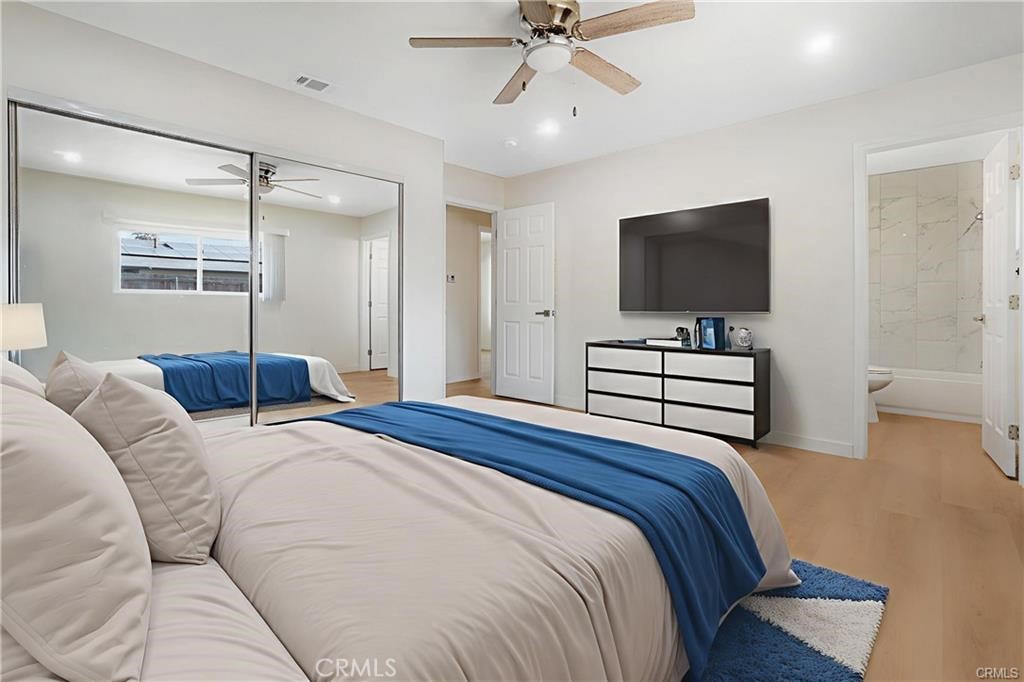 1594 Morgan Road San Bernardino, CA 92407 - Photo 9 of 31 a spacious bedroom with a bed and a flat screen television