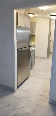 a metallic refrigerator freezer sitting in a kitchen