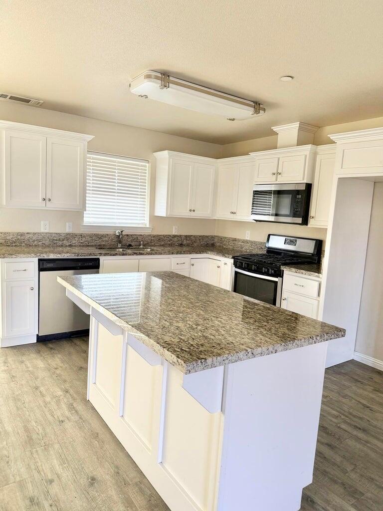 1310 North Belmont Road Exeter, CA 93221 - Photo 5 of 15 a kitchen with stainless steel appliances granite countertop a sink stove microwave and refrigerator