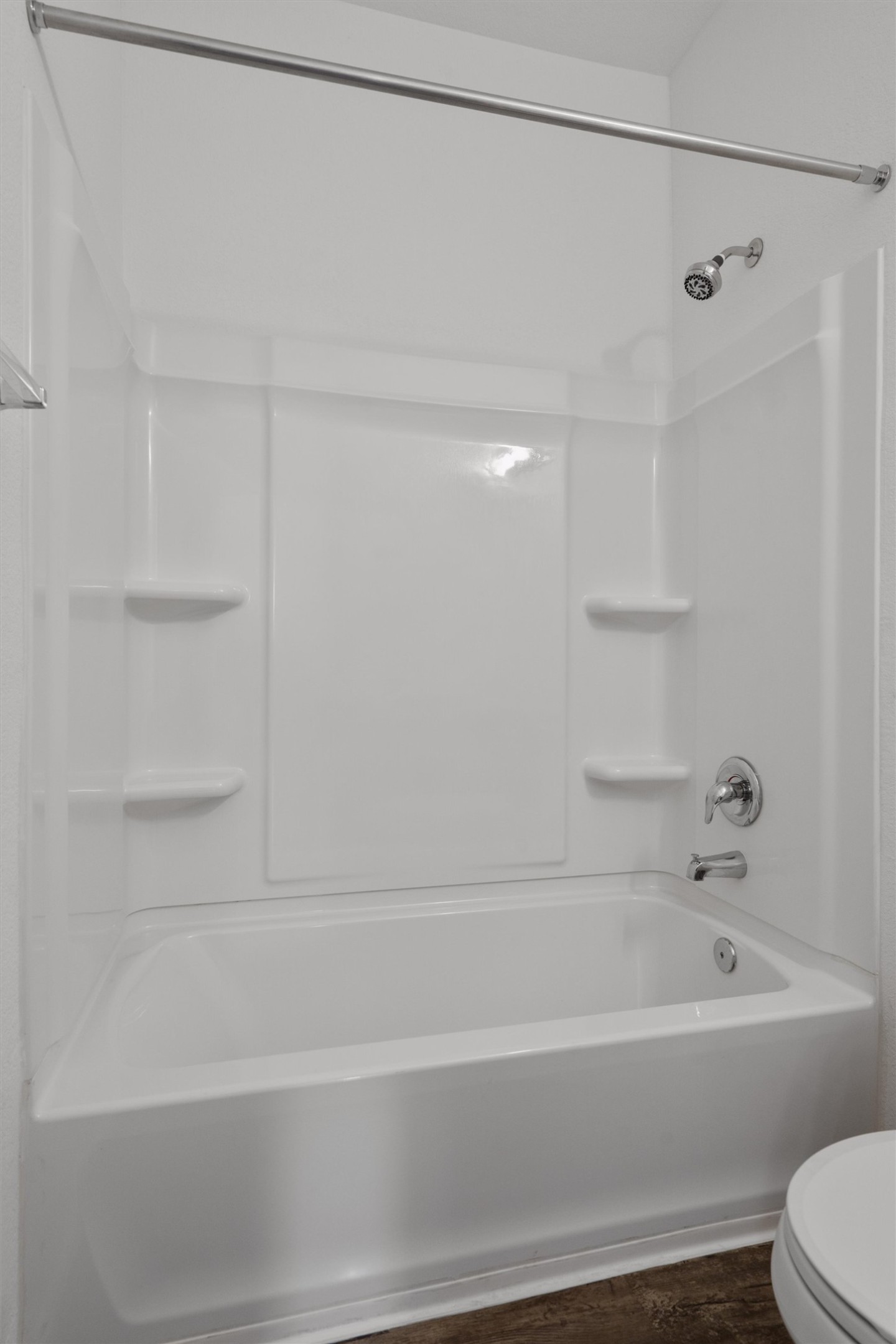 791 Circle Way Jarrell, TX 76537 - Photo 25 of 36 White bathtub and shower combination unit featuring an integrated soap dish and chrome fixtures