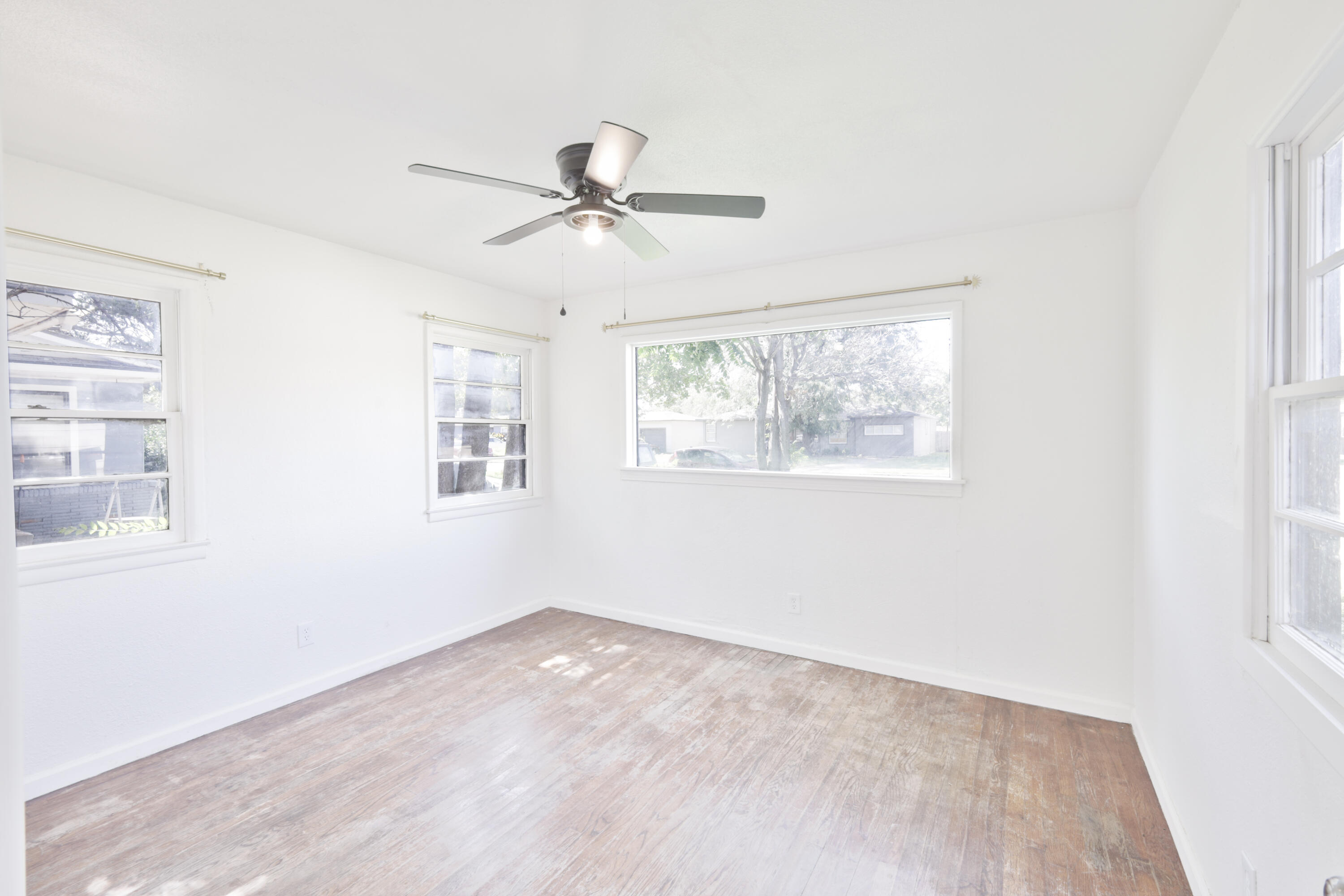 3812 31st Street Lubbock, TX 79410 - Photo 10 of 16 a view of empty room with wooden floor and fan