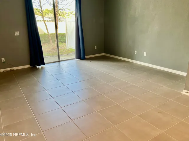 a view of an empty room with a sink and a window