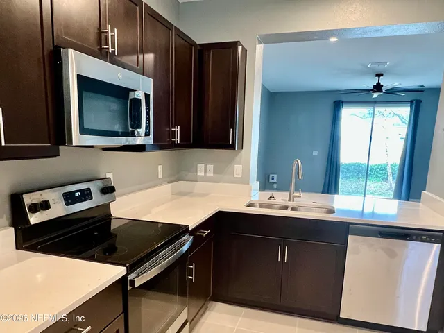 a kitchen with stainless steel appliances granite countertop a stove microwave and sink