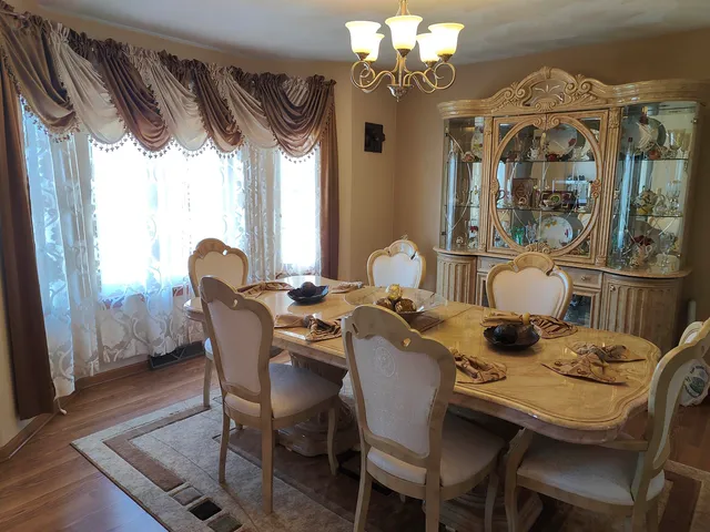 a dining room with furniture a chandelier and wooden floor