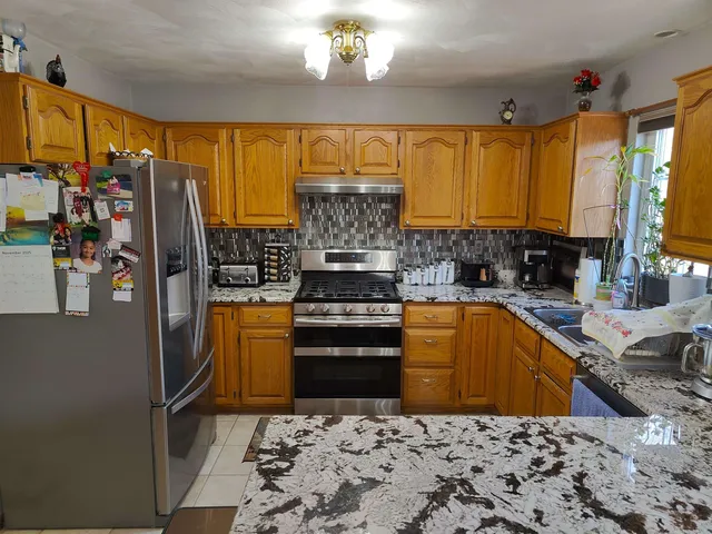 a kitchen with stainless steel appliances granite countertop a sink stove and refrigerator
