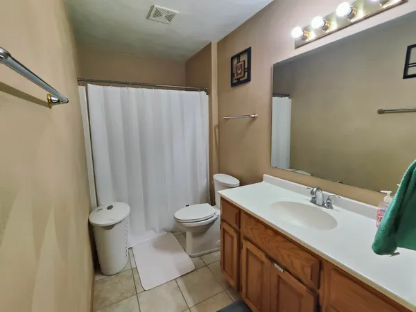 a bathroom with a granite countertop sink toilet and a mirror