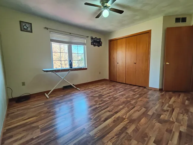 a view of a livingroom with wooden floor and a ceiling fan