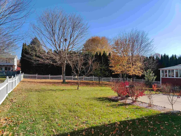 a view of swimming pool with lawn chairs and plants
