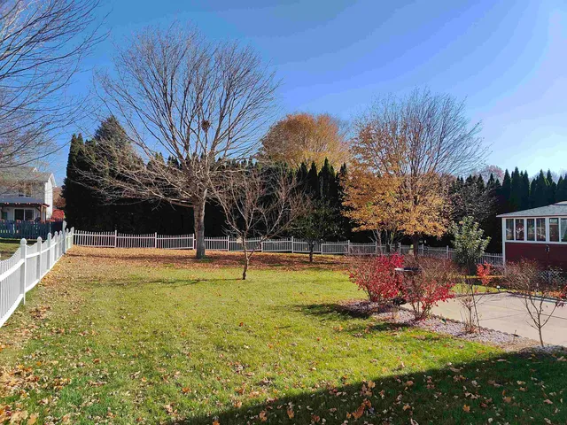 a view of swimming pool with lawn chairs and plants