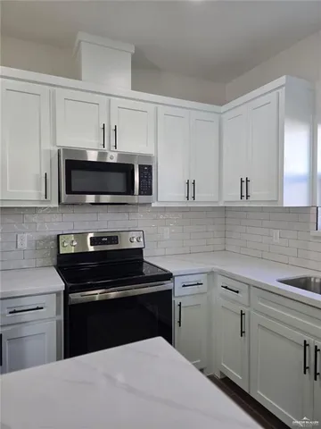 a kitchen with cabinets appliances a sink and a counter top