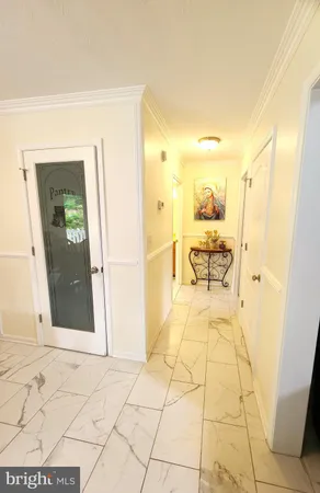 a view of a hallway with wooden floor and a bathroom