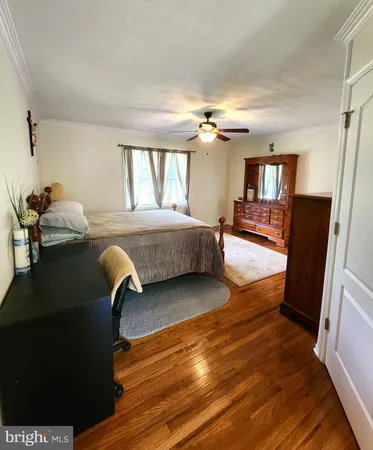 a bedroom with a bed wooden floor and chandelier