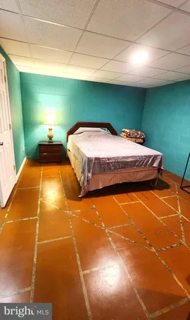 a bedroom with a bed and a potted plant