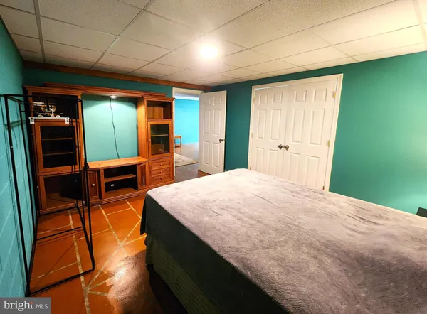 a spacious bedroom with a bed and a mirror