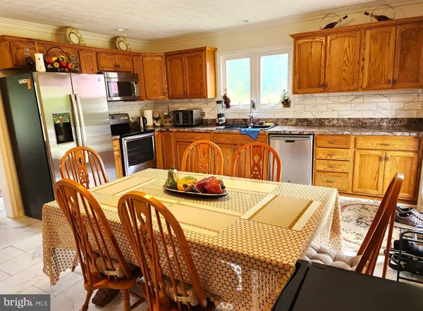 a kitchen with stainless steel appliances kitchen island granite countertop a refrigerator a sink a stove and island