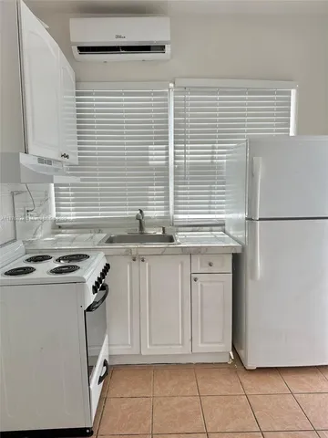 a kitchen with granite countertop white cabinets and white appliances