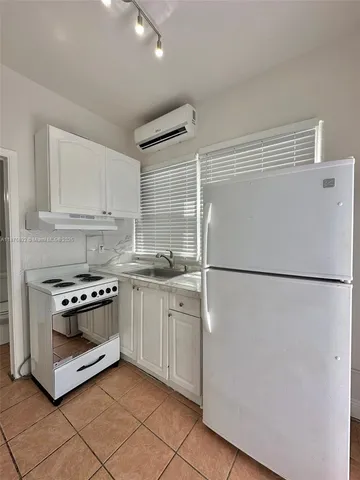 a white refrigerator freezer and a stove in a kitchen