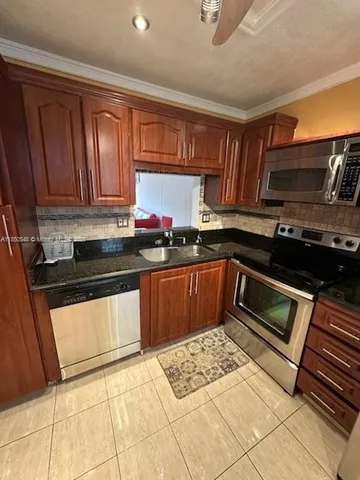 a kitchen with a sink stove and microwave