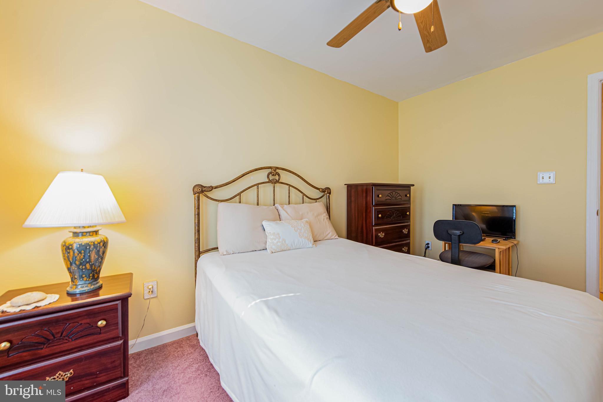 32408 Holly Ter Road Ocean View, DE 19970 - Photo 33 of 51 a bedroom with a bed and a lamp on table