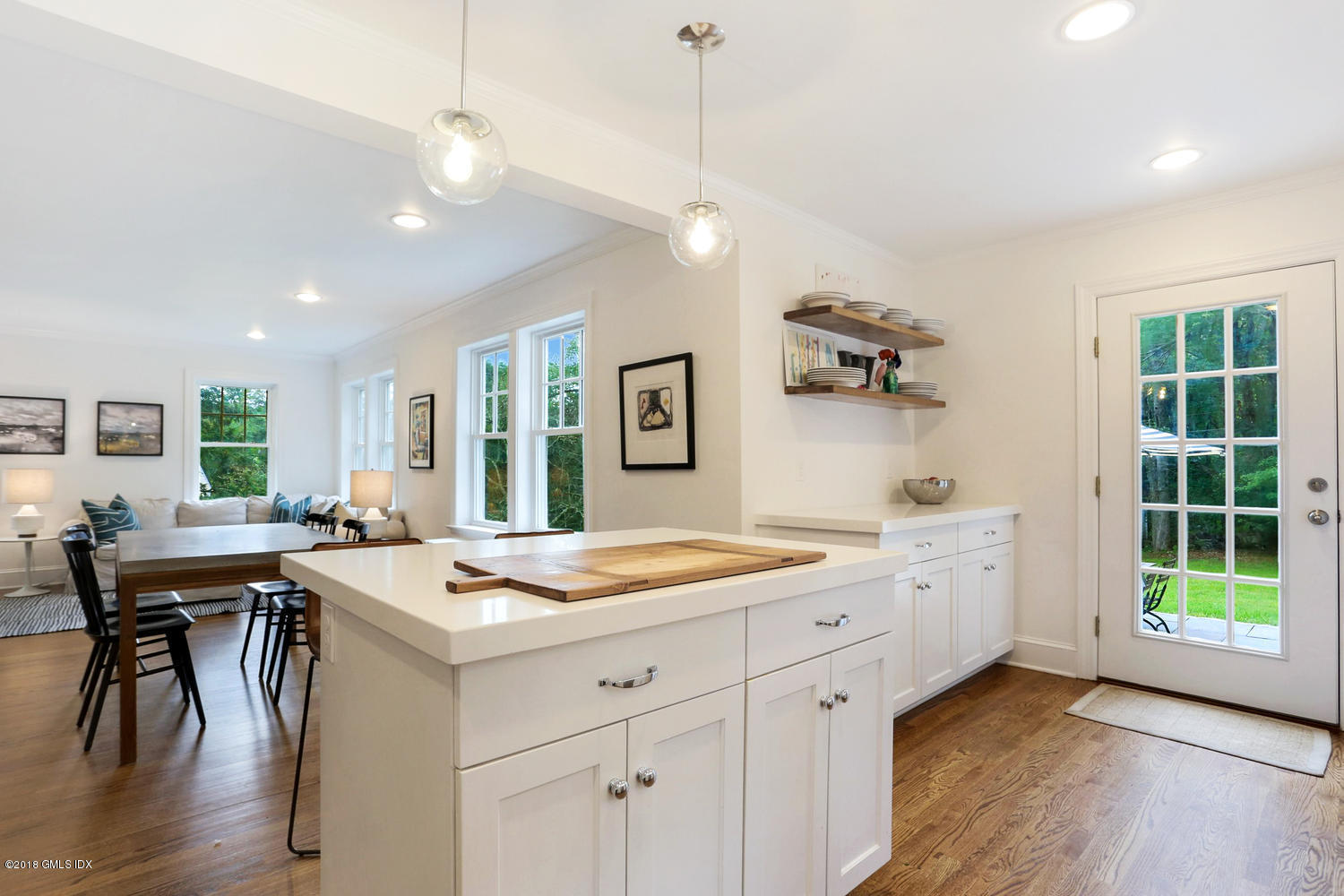 167 Riverbank Road Stamford, CT 06903 - Photo 17 of 38 a kitchen with a stove a sink a dining table and chairs with wooden floor