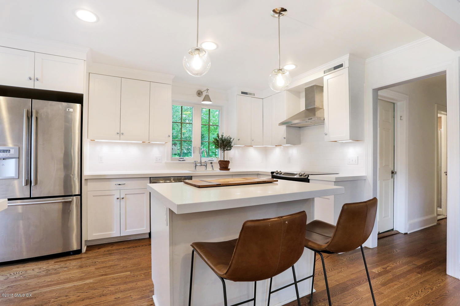 167 Riverbank Road Stamford, CT 06903 - Photo 18 of 38 a kitchen with stainless steel appliances granite countertop a sink a stove a refrigerator and island with wooden floor