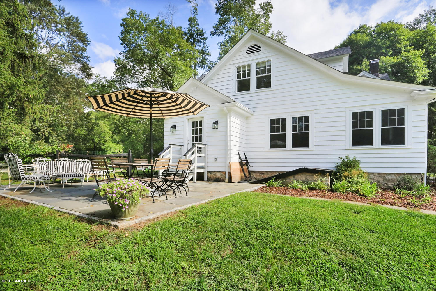 167 Riverbank Road Stamford, CT 06903 - Photo 28 of 38 a view of a patio with table and chairs and potted plants with wooden floor and fence
