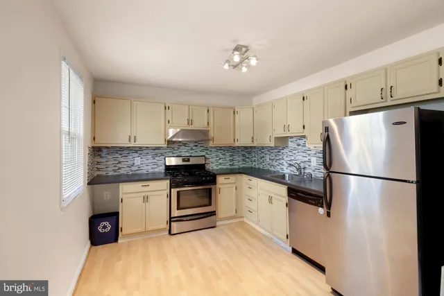 a kitchen with a refrigerator and a stove top oven
