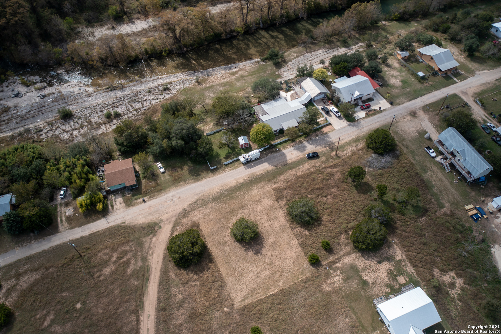 an aerial view of a house with a yard and parking