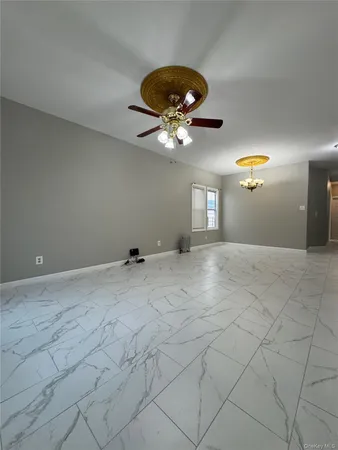 a view of a chandelier fan and hardwood floor