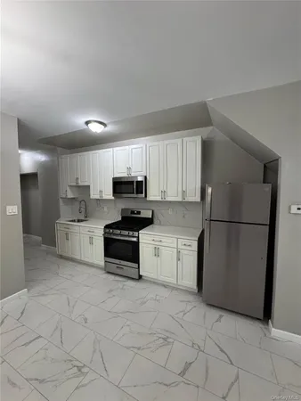 a kitchen with stainless steel appliances a refrigerator sink and cabinets