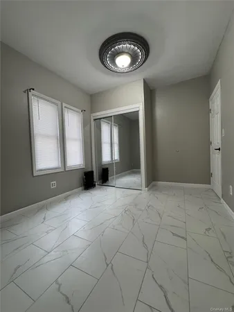 an empty room with windows and closet