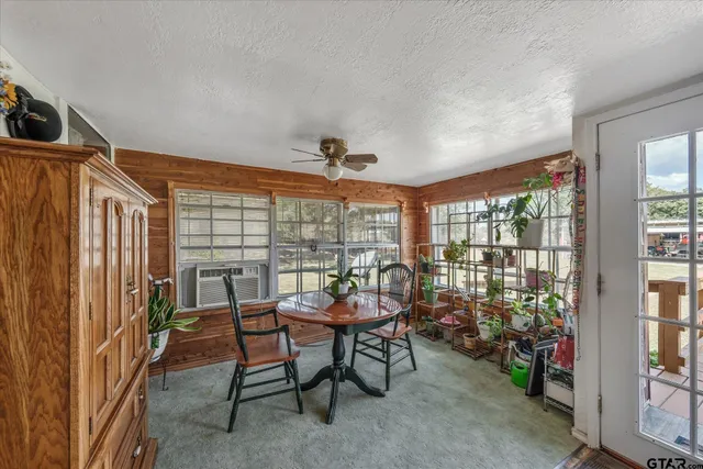 a dining room with furniture and a floor to ceiling window