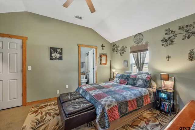 a bedroom with a bed and dresser with mirror