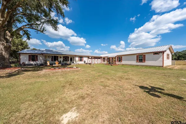a front view of house with yard and swimming pool