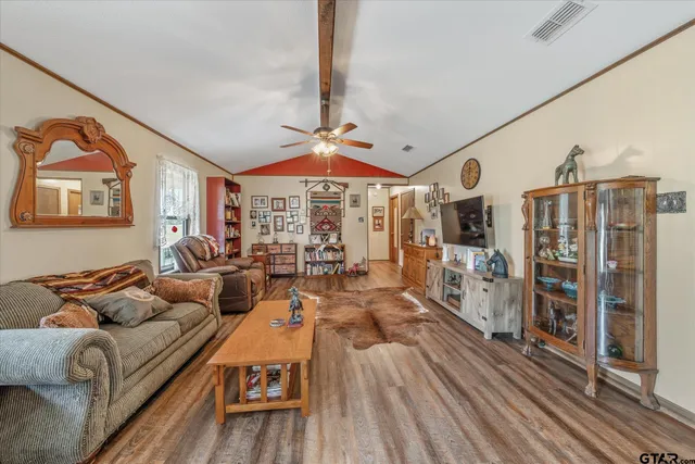 a living room with furniture a flat screen tv and a floor to ceiling window